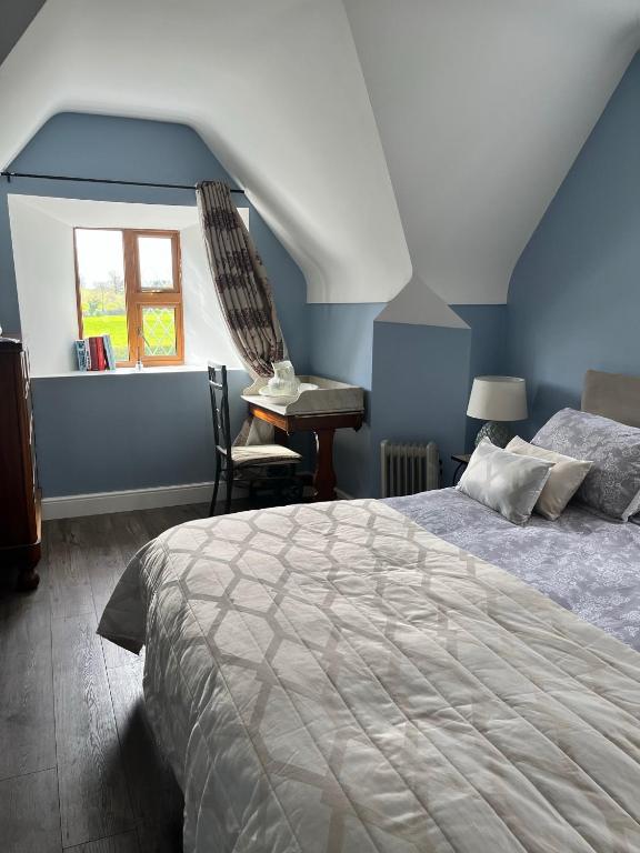 a bedroom with a bed and a chair and a window at Stone Lodge B&B in Balrath