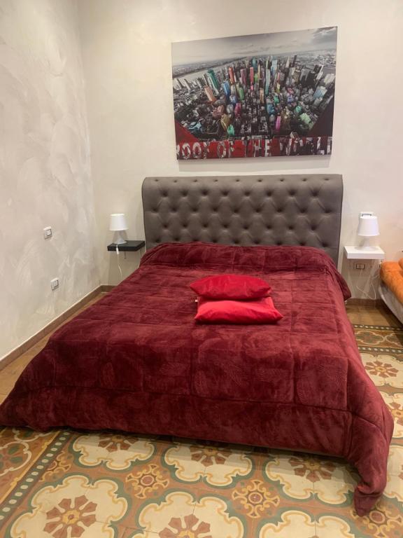 una camera da letto con un grande letto rosso con cuscini rossi di Brigata sea view a Bari