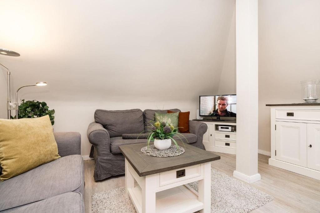 ein Wohnzimmer mit einem Sofa und einem TV in der Unterkunft Haus Marell 1.OG Wohnung 2 "West" in Wenningstedt-Braderup
