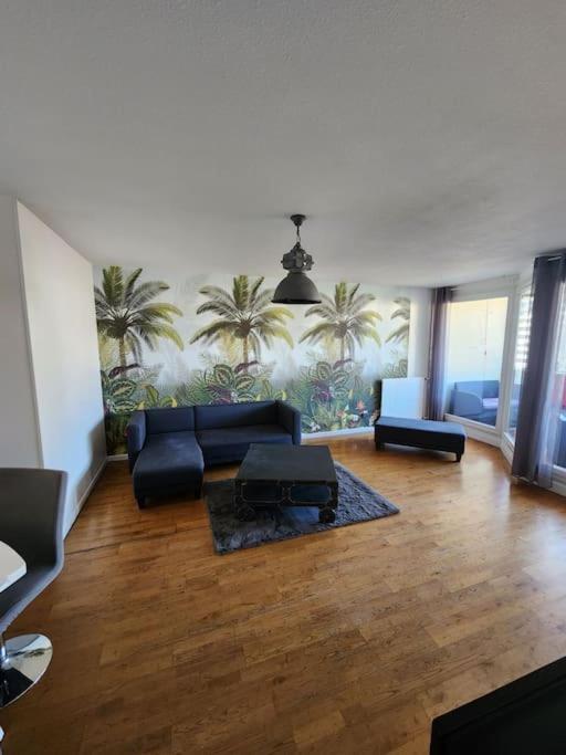 uma sala de estar com um sofá, cadeiras e palmeiras em Appartement T4 très spacieux em Grenoble