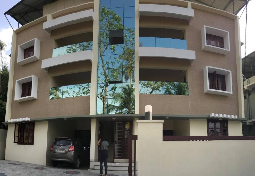 a woman standing in front of a building at Athrakkattu Enclave 6 Bedroom Luxury Apartment in Trivandrum