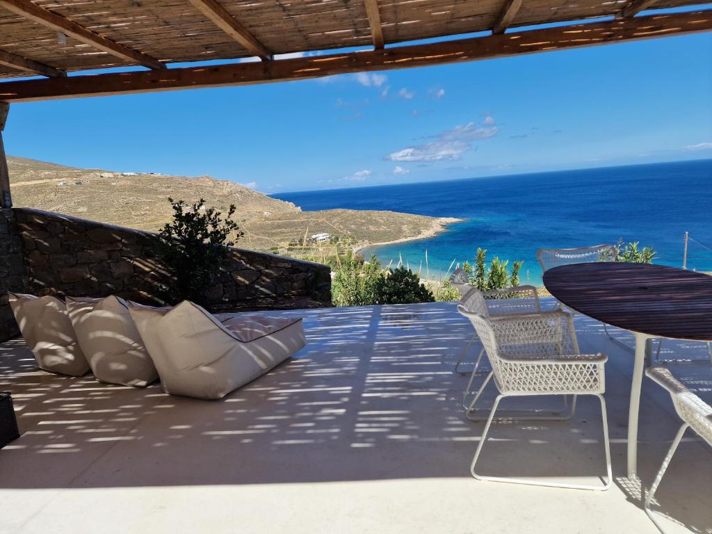 a patio with a table and chairs and the ocean at Blue Sea Villa in Serifos Chora