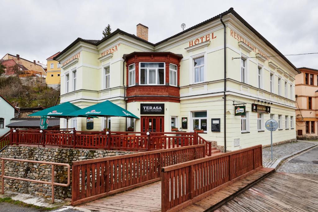 a hotel with tables and umbrellas in front of it at Hotel Terasa in Vimperk