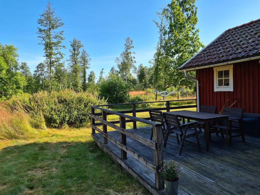 a wooden deck with a table and chairs on a house at Trevligt Torp i vacker natur in Mellerud