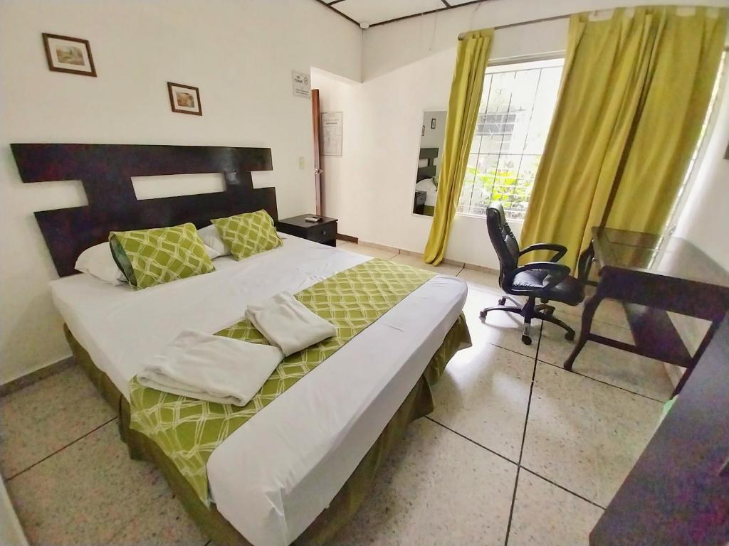 a bedroom with a bed and a desk and a window at Suites & Apartments San Benito - Zona Rosa in San Salvador
