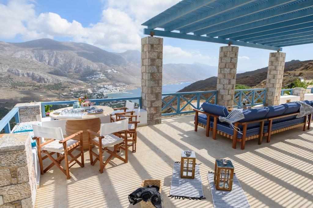 una terraza con mesa, sillas y vistas. en Tholariani Villas, en Amorgós