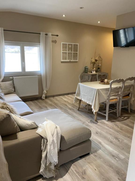 een woonkamer met een bank en een tafel bij Les Gîtes de La Petite Campagne in Mane