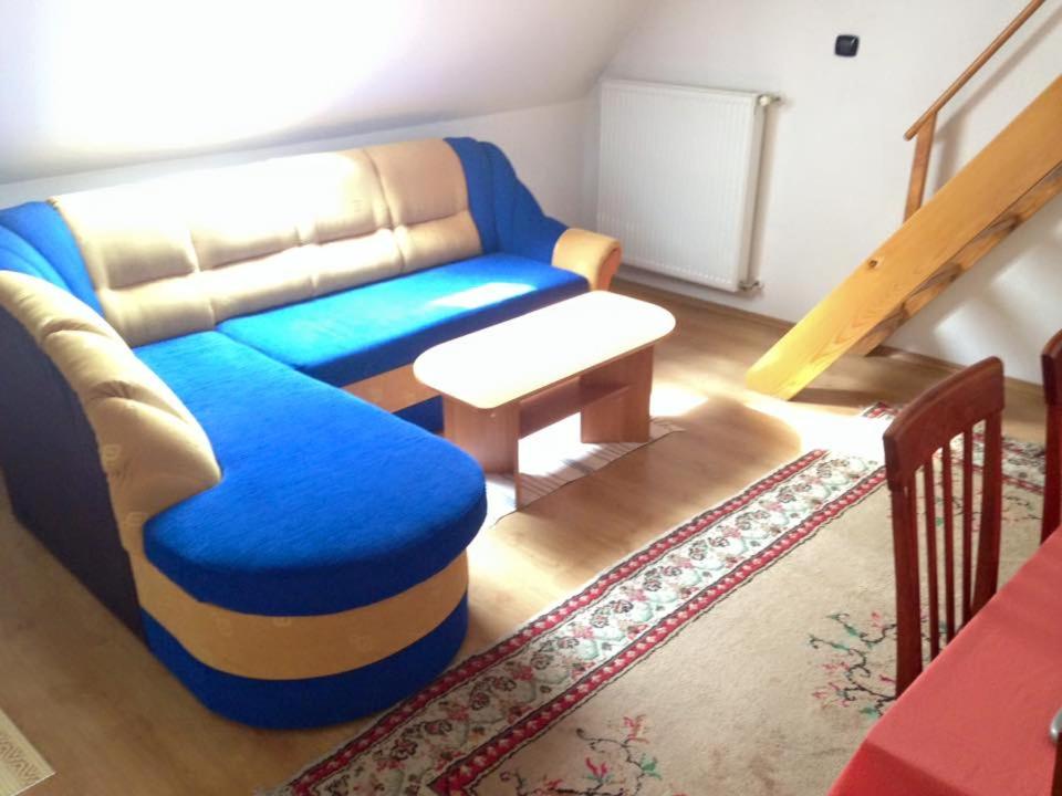 a living room with a blue couch and a table at Apartmani Lucija in Vrata