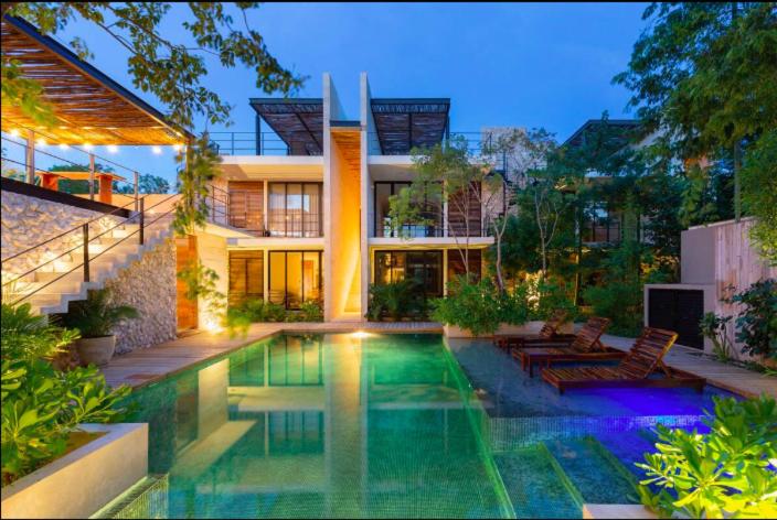 una casa con una piscina di fronte di Cordelia 2BedBath a Tulum