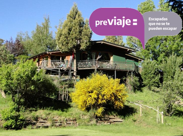 a house on a hill with a purple sign that says preserve at Abedules in Dina Huapi