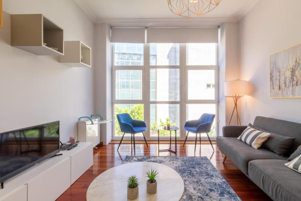 ein Wohnzimmer mit einem Sofa und einem TV in der Unterkunft Luxury Loft, Centro in Vigo