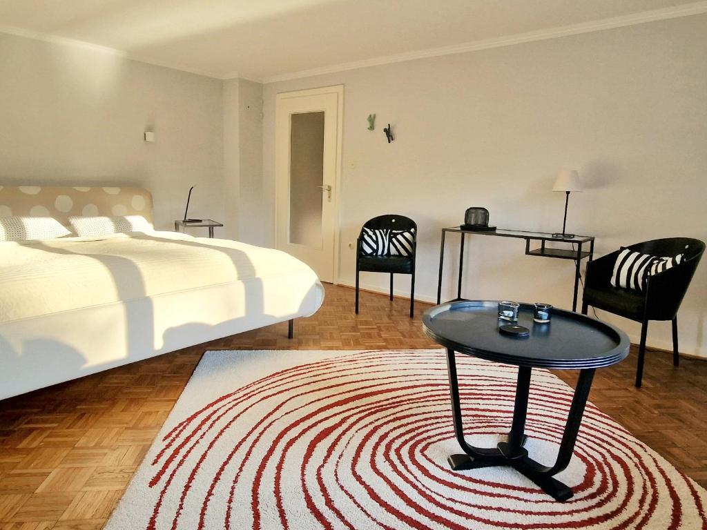 1 dormitorio con 1 cama, mesa y sillas en Kieler Eiderparadies, en Flintbek