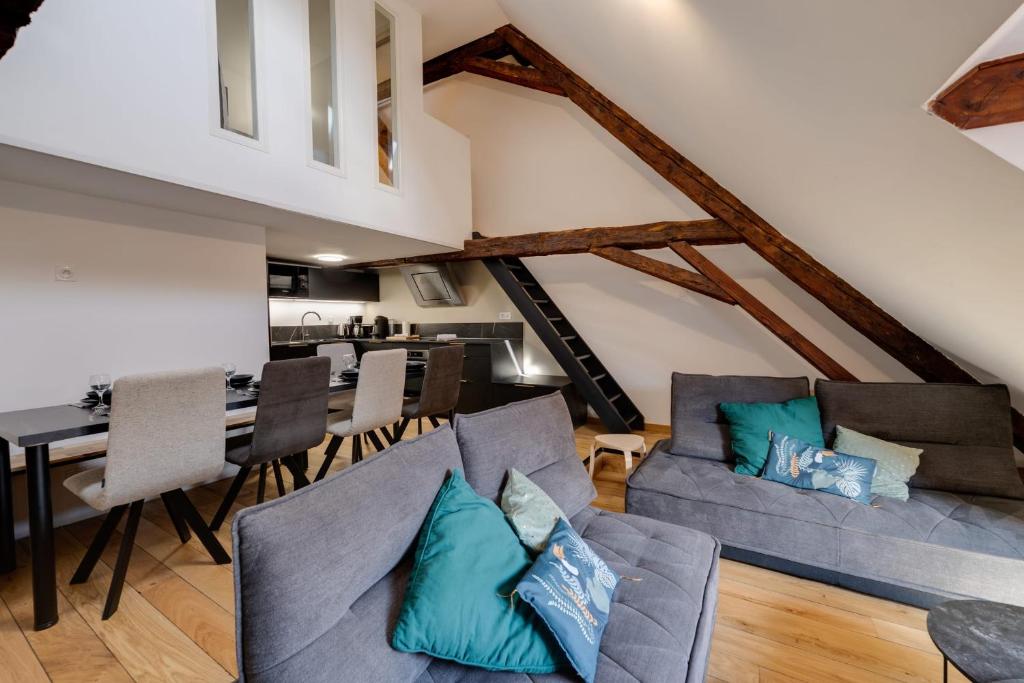 un soggiorno con divano e una sala da pranzo di Le SeptQatre - Grand triplex au cœur de la Vieille Ville ad Annecy