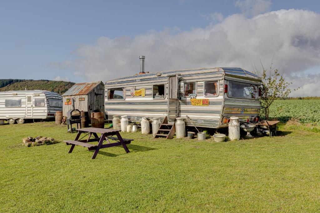 an rv parked in a field with a picnic table at 2 x Double Bed Glamping Wagon at Dalby Forest in Scarborough