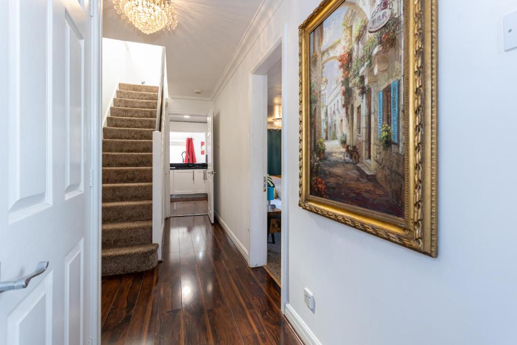 a hallway with a painting on the wall and a staircase at Renfrew House in Bolton