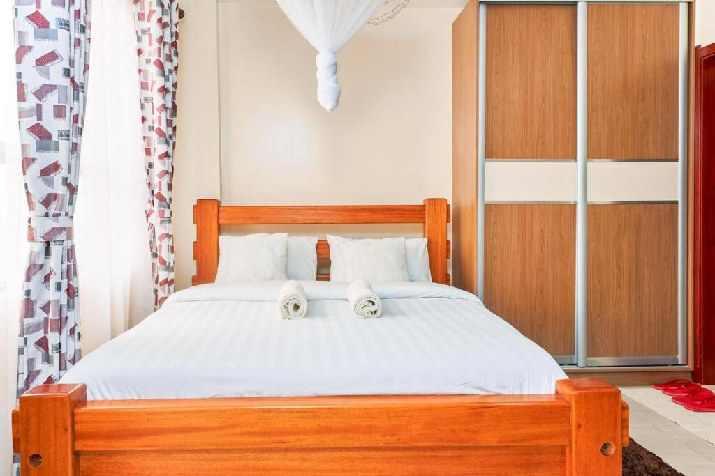 a bedroom with a wooden bed with two towels on it at City view luxury Suites in Nairobi