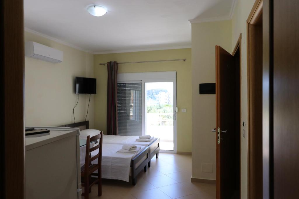 a bedroom with a bed and a kitchen with a window at Casa Blanca Rooms in Himare