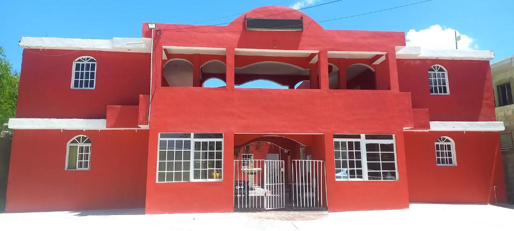 a red building with a gate in front of it at Hotel Punto4 in Punta Cana