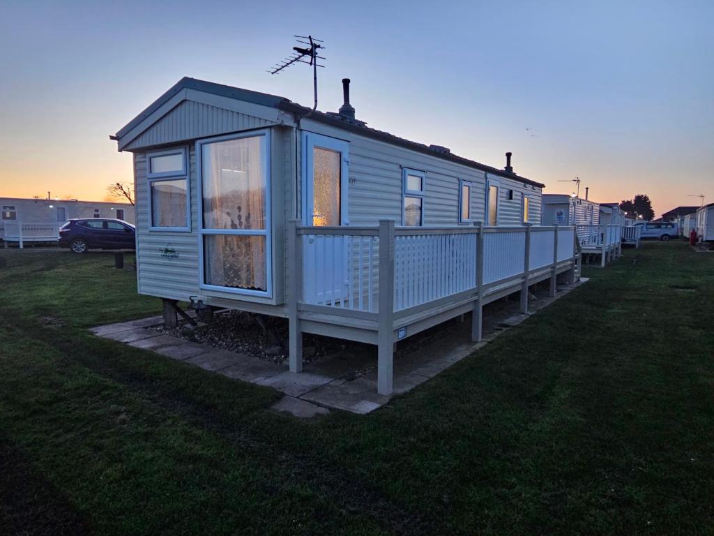 a blue tiny house sitting in the grass at Esmeralda's Caravan Hire Mablethorpe in Mablethorpe