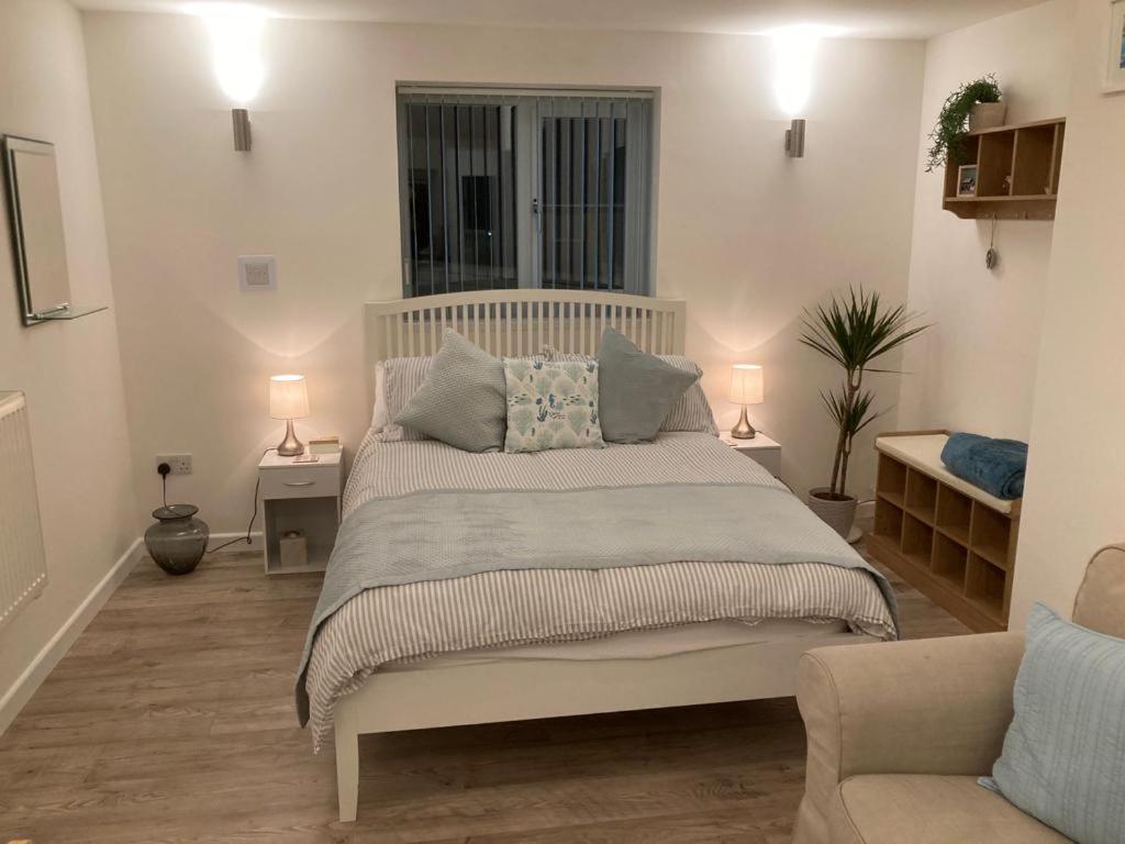Un dormitorio con una cama blanca con almohadas. en The Haven 2 night minimum en Torpoint