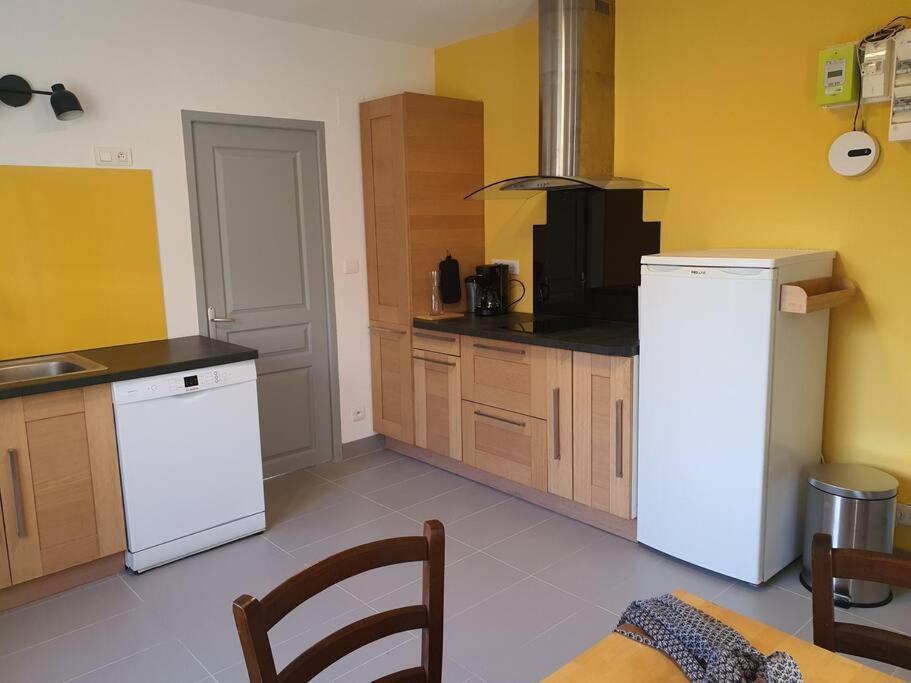 een keuken met een witte koelkast en een fornuis bij Le Tournesol, Appartement T1 bis in Héricourt