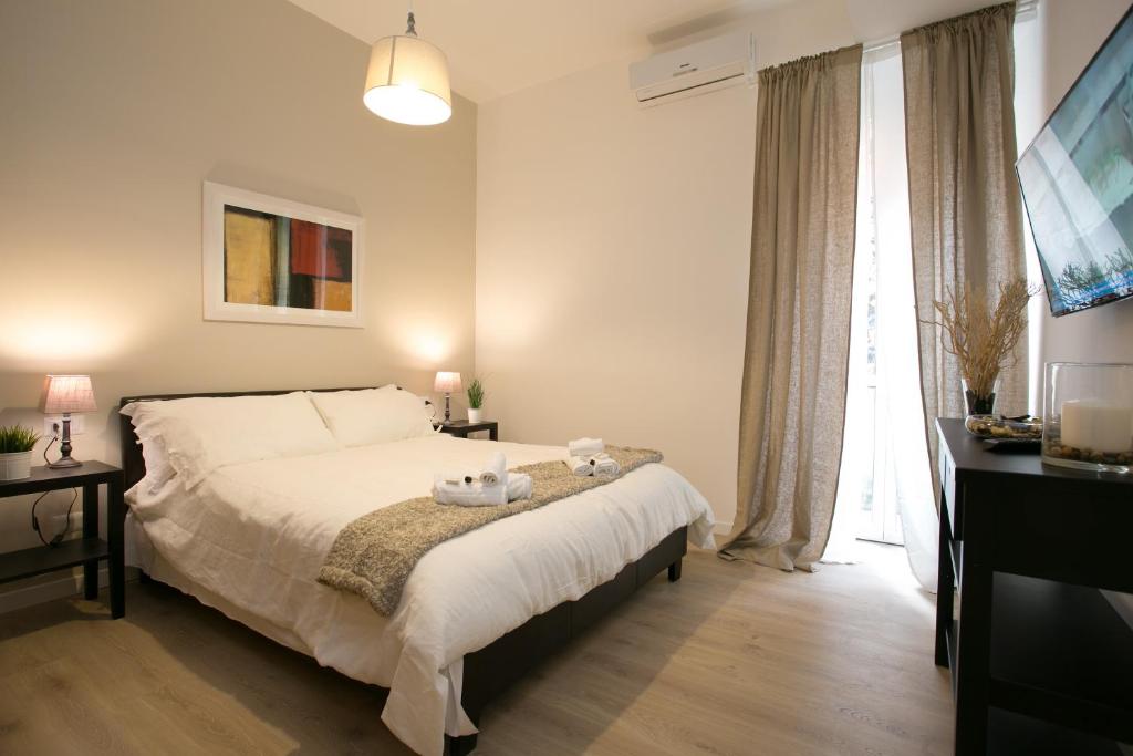 um quarto com uma cama grande e lençóis brancos em Thebestinrome Piazza del Popolo - Vico em Roma