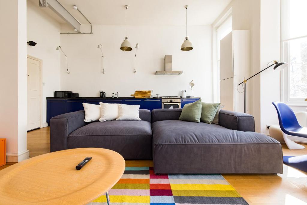 a living room with a couch and a table at Stylish & Spacious Notting Hill Loft in London