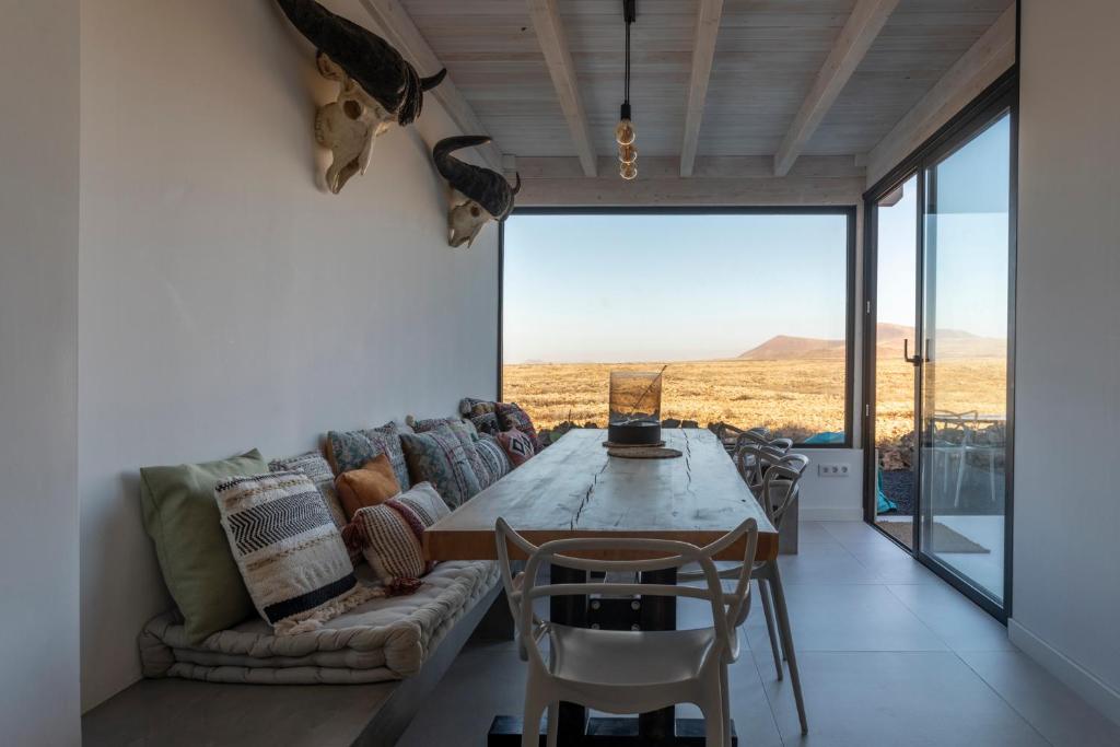 een woonkamer met een bank en een tafel bij Villa Calderón Hondo. Top design , views and pool Lajares-Corralejo in Corralejo