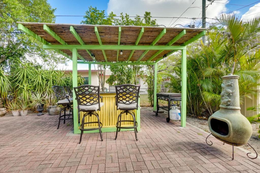 a patio with a table and chairs under a pergola at Clearwater Vacation Home Rental with Tiki Bar! in Clearwater