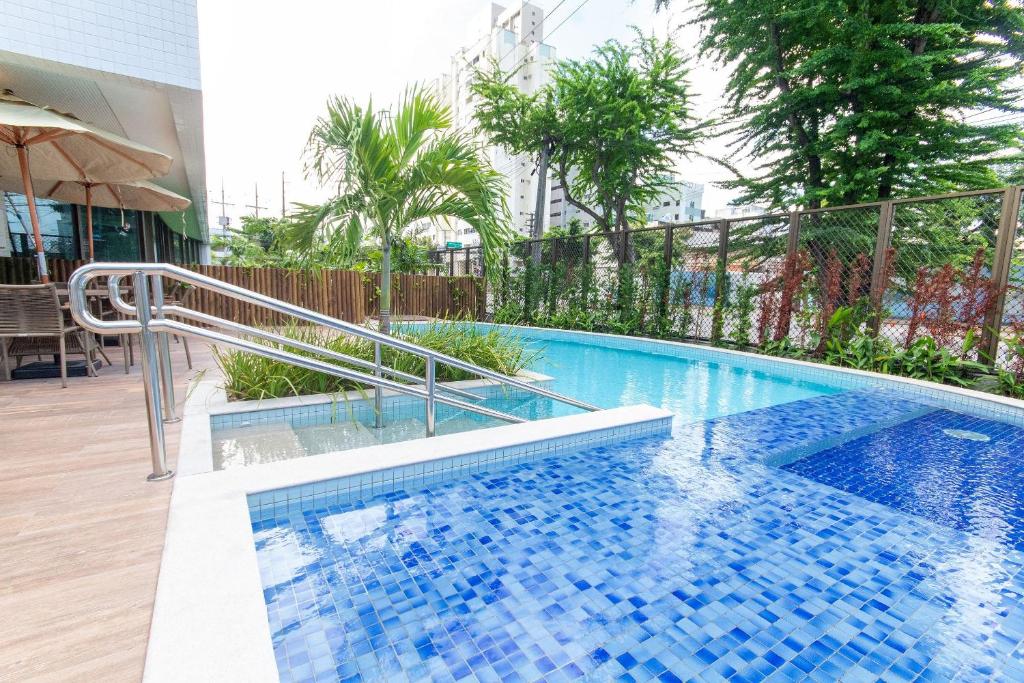 una piscina con azulejos azules en un edificio en Parque Shopping #2206 - Apartamento em Boa Viagem Housi por Carpediem en Recife