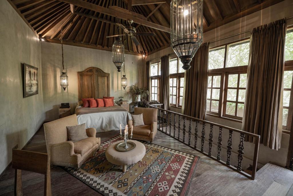 a bedroom with a bed and a couch and a table at Balquisse Heritage Hotel in Jimbaran