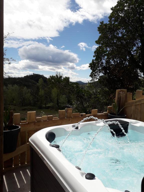 un bain à remous sur une terrasse avec vue dans l'établissement Cocoon Gîtes 2-4 ou 6 pers avec jacuzzi entre Anduze et Alès, à Carnoulès