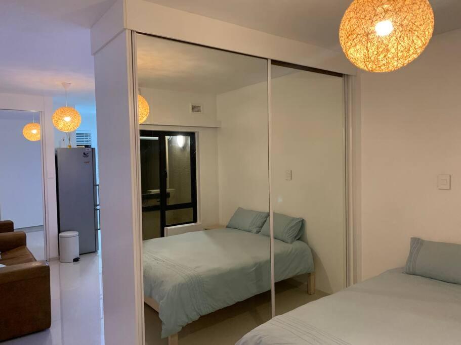 a bedroom with a mirror and a bed in it at Sea Breeze Studio in Umdloti