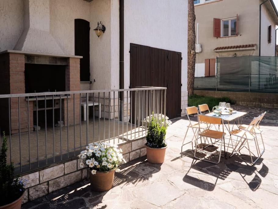 un patio con tavolo, sedie e camino di ( Art Of Relax ) La Casa dei 4 pini a Cervia