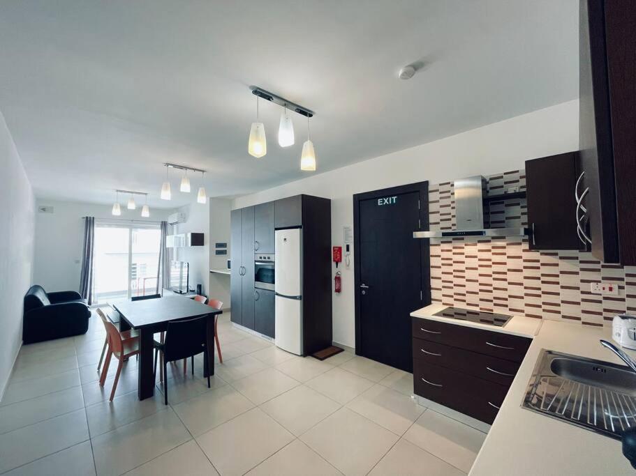 a kitchen with a table and a dining room at Modern St.Julian's Heart 2 Bed 2 Bath | Paceville in St. Julianʼs