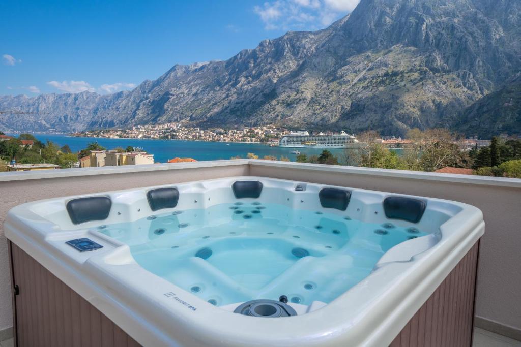 a hot tub on a balcony with a mountain at Marea DeLuxe Apartments in Kotor