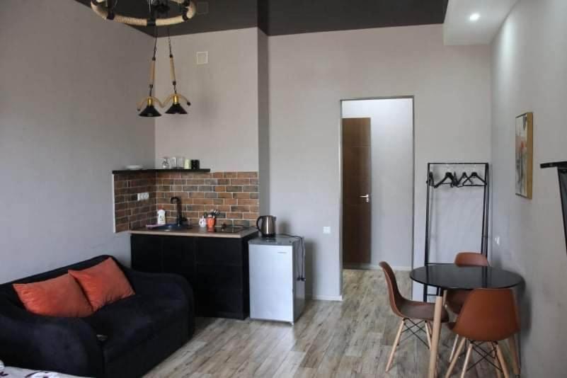 uma sala de estar com um sofá, uma mesa e uma cozinha em Avlabari Apartaments Nia em Tbilisi