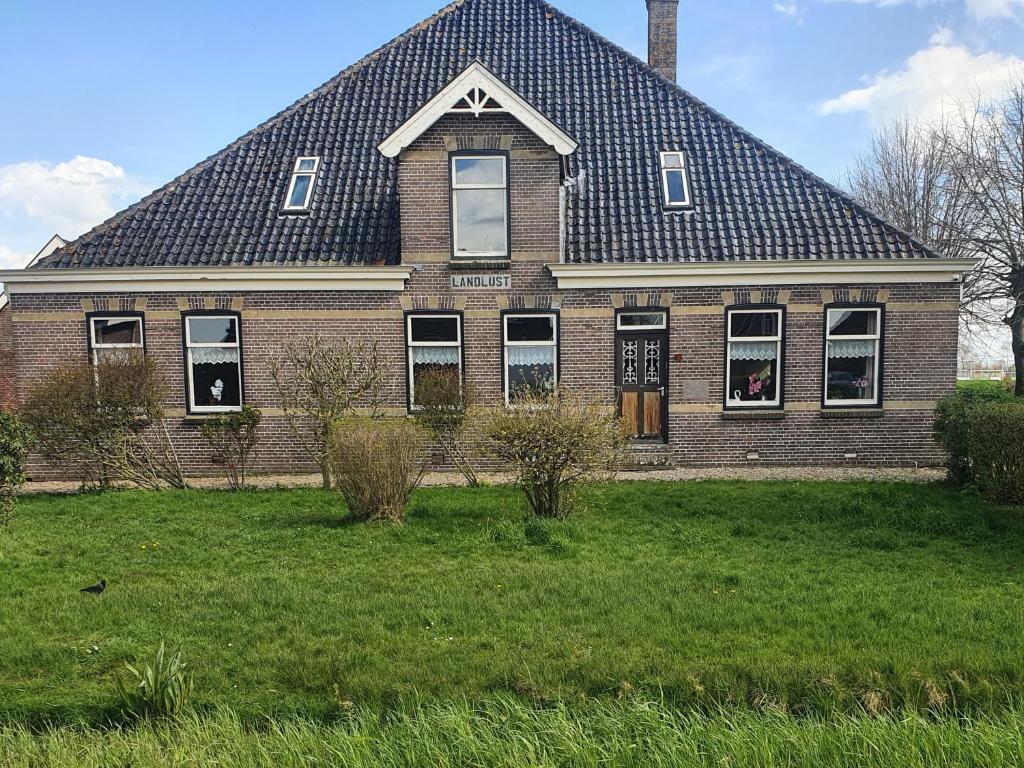 ein großes Backsteinhaus mit einem Gameradach in der Unterkunft Landlust in Purmerend