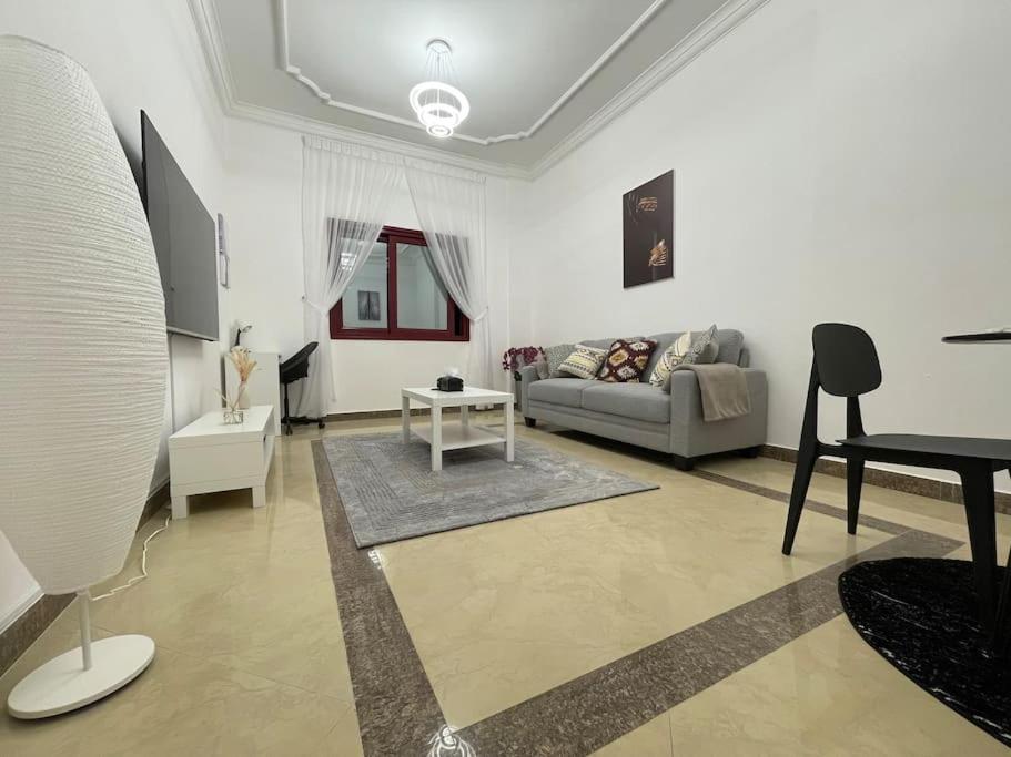 a living room with a couch and a table at Beach view, Cozy 2BR apartment in Sharjah