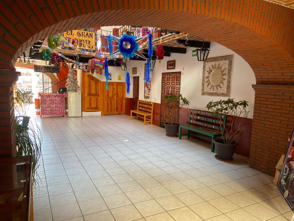 an archway in a building with flags and benches at EL GRAN TORIL in Taxco de Alarcón