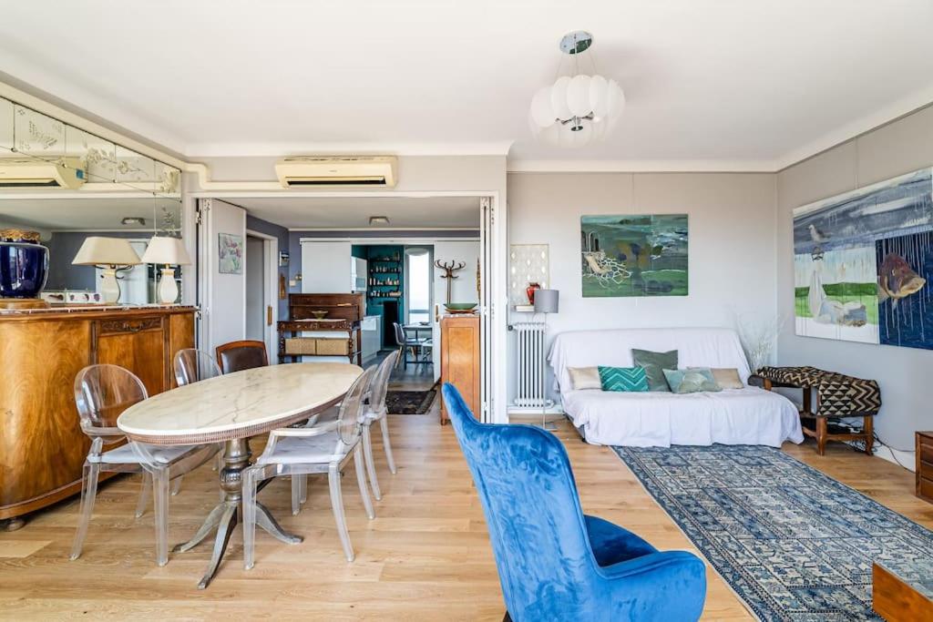 sala de estar con mesa, sillas y cama en Marseille: appartement standing vue sur mer, en Marsella