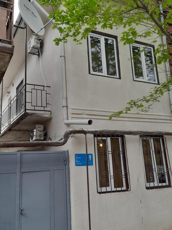 a white building with a door and a balcony at Number 9 in Tbilisi City