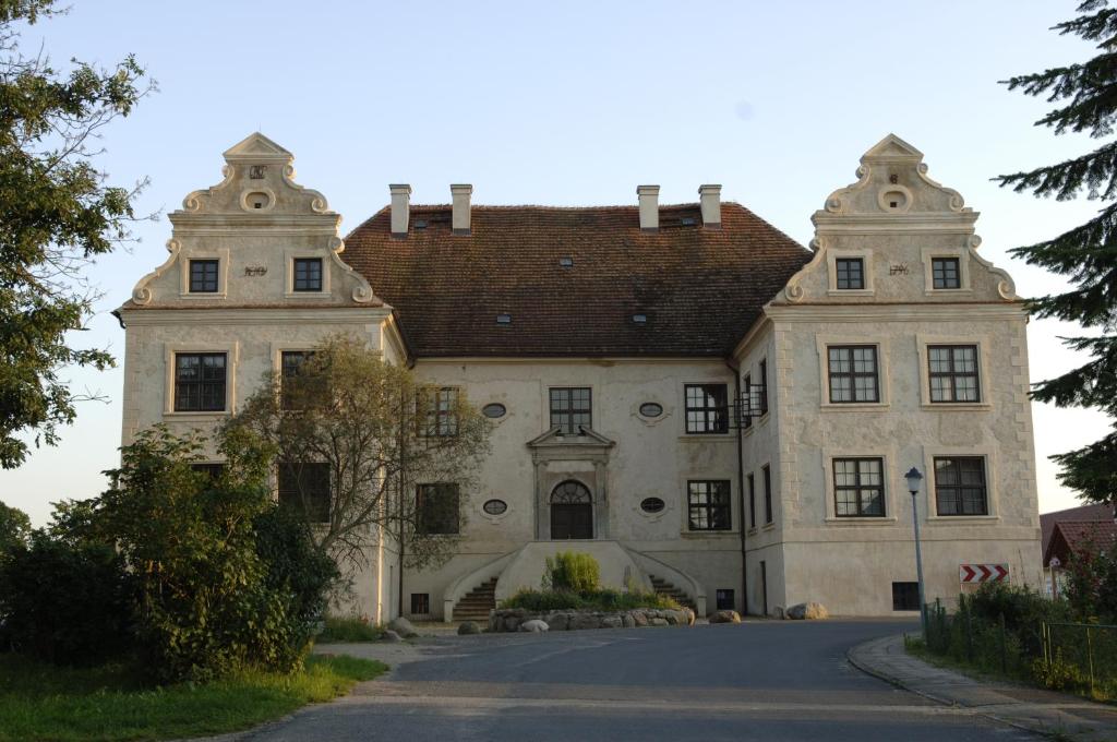 a large stone building with a red roof at Schloss Schmarsow, Wohnung BLAU 