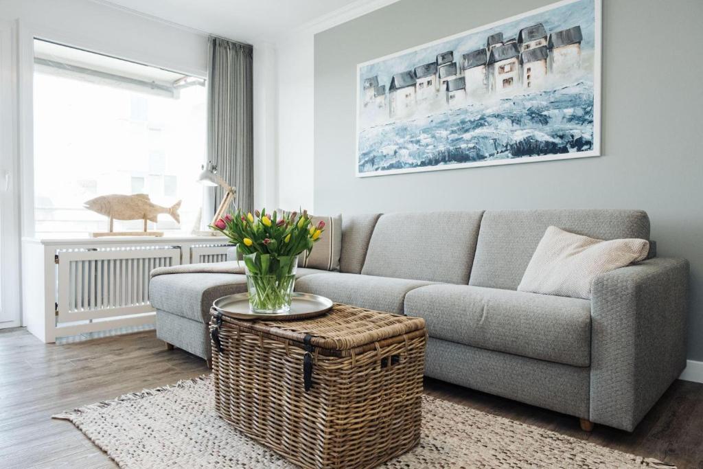 sala de estar con sofá y mesa en Norderhoog-Whg-35-1-OG-Wohnung-35, en Westerland