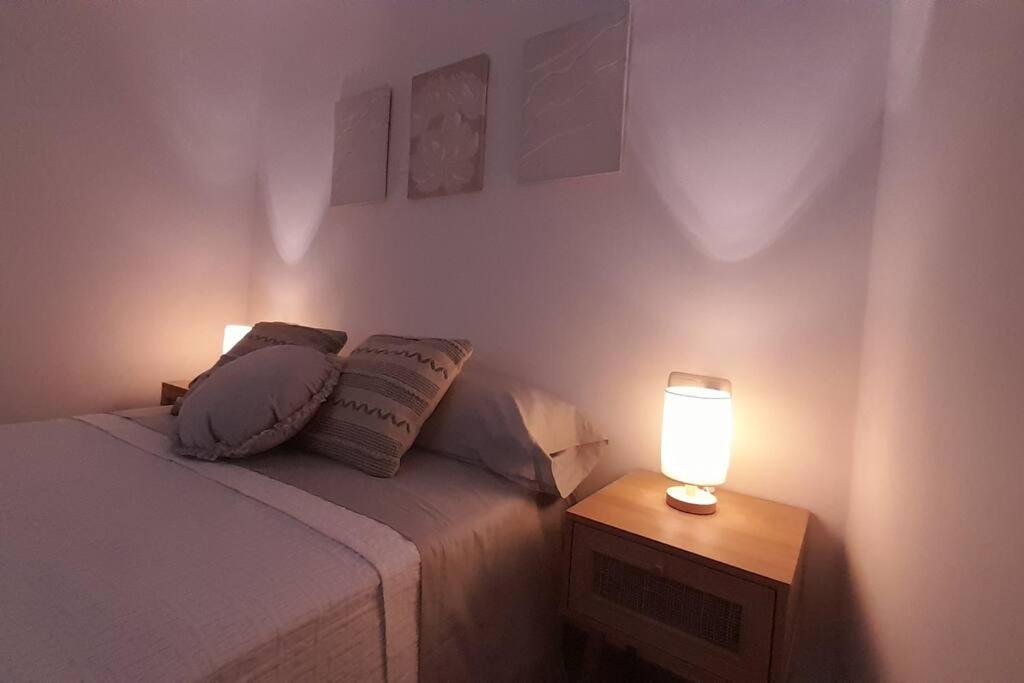 een slaapkamer met een bed en een tafel met een lamp bij Rinconcito en el almendral in Jaén