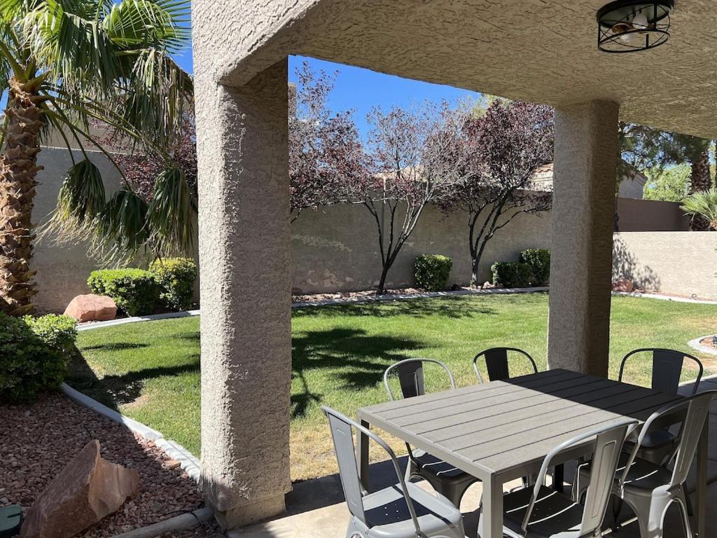 een witte tafel en stoelen op een patio met een tuin bij 3 Bedroom 2 Bath Oasis in Cozy Neighborhood in Las Vegas