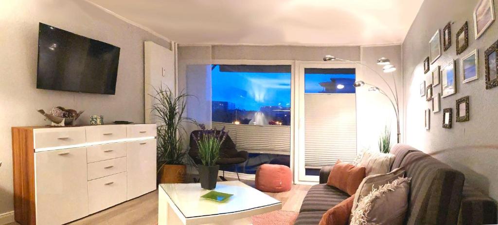 sala de estar con sofá y ventana grande en Norderhoog-Whg-38-1-OG-Wohnung-38, en Westerland