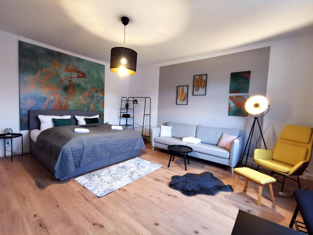 ein Schlafzimmer mit einem Bett und einem Sofa in der Unterkunft BohnApartments EGA Stadtblick - Garten - WLAN - Nähe Theater EGA und Messe in Erfurt