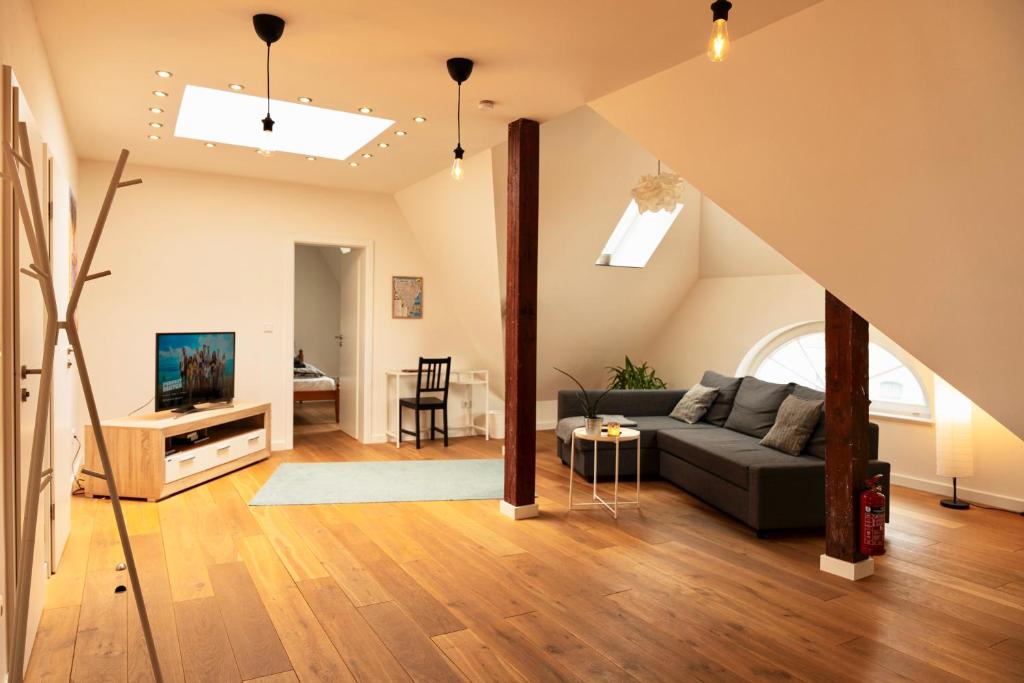 a living room with a couch and a tv at Wölkchen - Wohnung mit Balkon, Holzdielen & TV in Bremerhaven