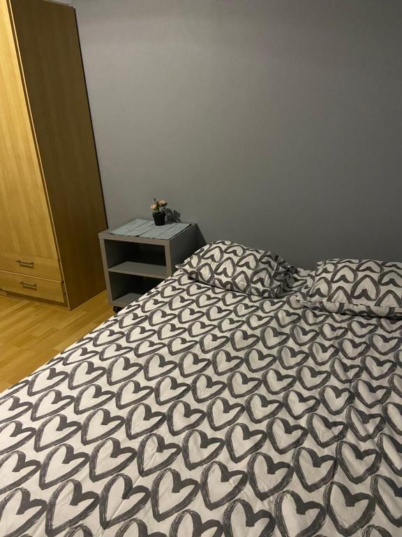 a bed with a black and white comforter in a bedroom at Centrum Apart in Krakow